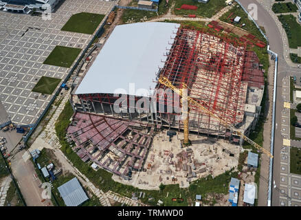 Luftaufnahme von einer großen industriellen Gebäude mit einem Turm Kran Stockfoto