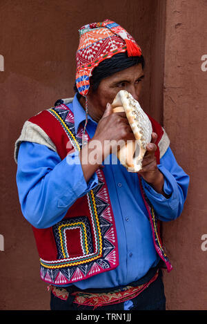 Heiliges Tal, Cusco, Peru - 13.Oktober 2018: Der indigenen Quechua Mann Schläge auf eine Muschel Stockfoto