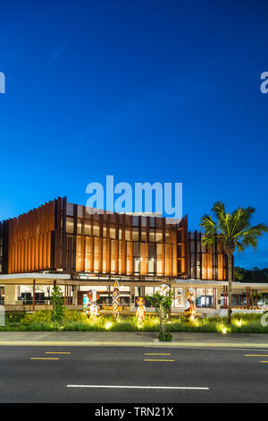 Die Fassade der Cairns Performing Arts Center in der Dämmerung beleuchtet. Eine Reihe von "bagu "heimischen Skulpturen sitzen an der Vorderseite des Zentrums. Cairn Stockfoto