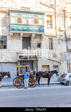 Valetta, Malta - 13. September 2015: ein Fahrer steht von seinem Pferd und Wagen. Sie werden von den Touristen für Ausflüge genutzt. Stockfoto