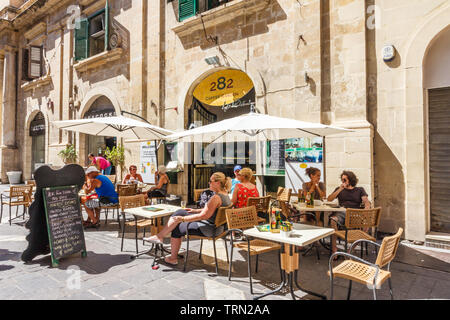 Valetta, Malta - 13. September 2015: Touristen saßen draußen ein Cafe in einem Quadrat. Die Stadt ist ein beliebter Hafen mit Kreuzfahrtschiffen. Stockfoto