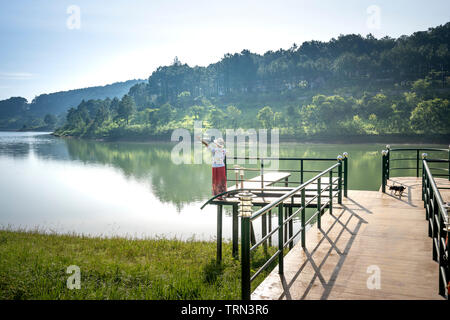 Tuyen Lam See, Stadt Da Lat, Provinz Lam Dong, Vietnam - 22. Mai 2019: Eine weibliche Reisende entspannen auf dem Pier in Tuyen Lam See, Stadt Da Lat, Lam Stockfoto