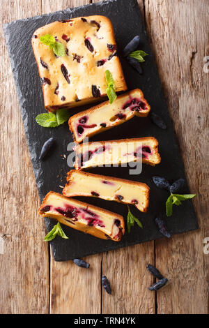 Berry Kuchen mit Geißblatt und Minze auf dem Board closeup auf einem Holztisch. Vertikal oben Ansicht von oben Stockfoto