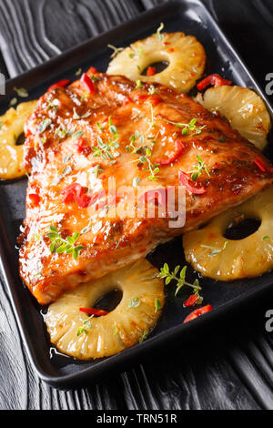 Thailändische Küche von lachsfilet überbacken mit Ananas in Chili süßen Soße close-up auf einem Teller auf den Tisch. Vertikale Stockfoto