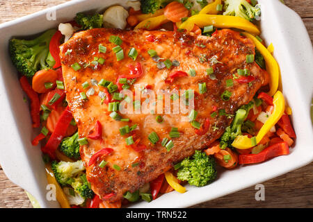 Würzig Gebackenes Lachsfilet mit Gemüse und Kräutern close-up in einer Auflaufform auf den Tisch. horizontal oben Ansicht von oben Stockfoto