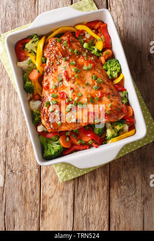 Gebackenen Lachs mit Sommergemüse close-up in einer Auflaufform auf den Tisch. Vertikal oben Ansicht von oben Stockfoto