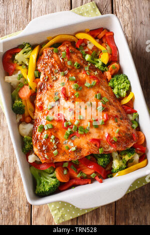 Red Fischfilet gebacken mit Gemüse, Gewürze und Kräuter close-up in einer Auflaufform auf den Tisch. Vertikal oben Ansicht von oben Stockfoto