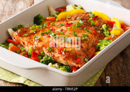 Gesunde Ernährung Mahlzeit Gebackenes Lachsfilet mit Gemüse und Kräutern close-up in einer Auflaufform auf den Tisch. Horizontale Stockfoto