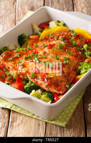 Würzig Gebackenes Lachsfilet mit Gemüse und Kräutern close-up in einer Auflaufform auf den Tisch. Vertikale Stockfoto