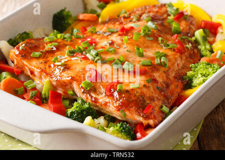 Gebackenen Lachs mit Sommergemüse close-up in einer Auflaufform auf den Tisch. Horizontale Stockfoto