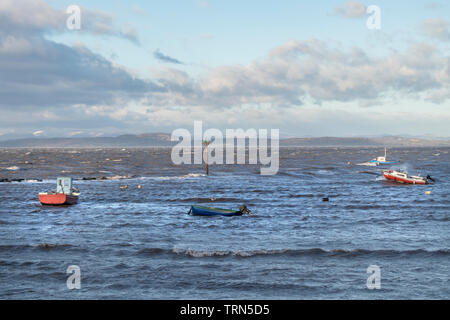 Sturm warf Fischerboote mit den schneebedeckten Bergen des Lake District Jenseits, Morecambe Bay, Lancashire, Großbritannien Stockfoto