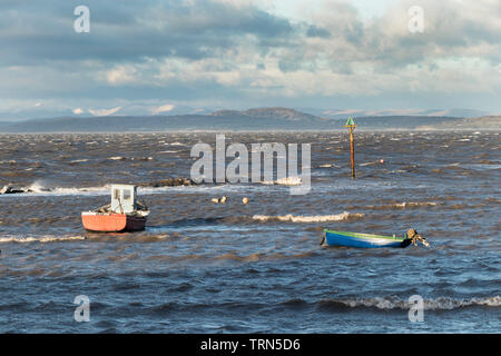 Sturm warf Fischerboote mit den schneebedeckten Bergen des Lake District Jenseits, Morecambe Bay, Lancashire, Großbritannien Stockfoto