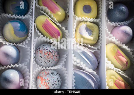 Eine Schachtel Pralinen in Pastellfarben sortiert Stockfoto