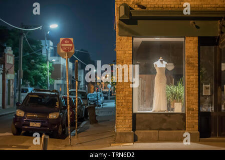 Geparkte Autos und ein Brautkleid in einem Schaufenster in der Nacht in der Nähe von Brunswick Street, Fitzroy, Victoria, Australien Stockfoto