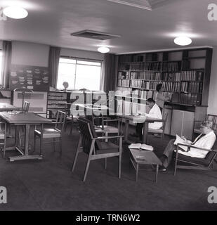 1965, historische, das medizinische Personal im Krankenhaus Reference Library oder Leseraum, Stoke Mandeville Hospital, Aylesbury, Buckhamingshire, England, UK. Beachten Sie die Zigarette Aschenbecher auf den Tischen, wie Rauchen - abgesehen von den Stationen selbst - war in vielen Teilen der Klinik erlaubt. Stockfoto