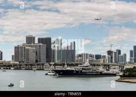 Miami, FL, Vereinigte Staaten - 20 April, 2019: Miami Skyline von Dodge Island an der Biscayne Bay gesehen. Lange Verkehr Brücke und Luxus Yacht in der Fo Stockfoto