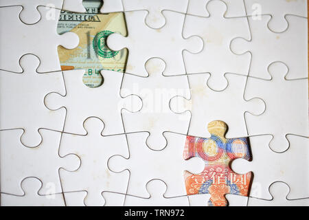 Geld hinter dem Puzzle sichtbar Stockfoto