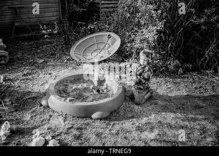 Zwei Jahre alter Junge, der in einer Sandgrube spielt, Medstead, Alton, Hampshire, England, Großbritannien. Stockfoto