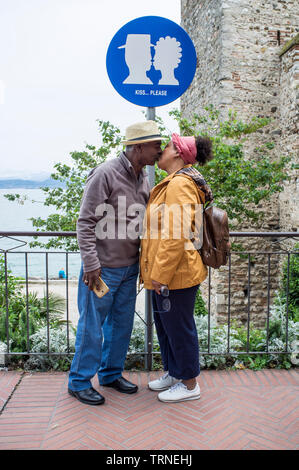 18. Mai 2019 - Sirmione, Gardasee, Italien - Paar mittleren Alters brasilianische Touristen, Küssen unter dem Zeichen: kiss Bitte Stockfoto
