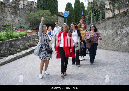 18. Mai 2019 - Sirmione, Gardasee, Italien - glückliche Gruppe der Brasilianischen Touristen, wandern mit einem Reiseleiter Stockfoto