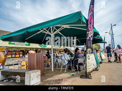 Essen und Trinken im Freien, der von einer grünen Plane auf Great Yarmouth, Norfolk Küste Stockfoto