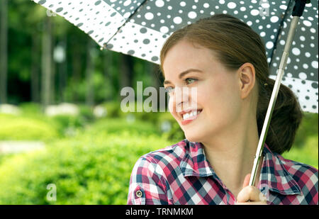 Junge kaukasier Frau mit Schirm Stockfoto