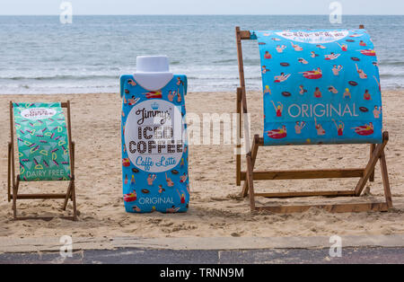 Jimmys Iced Coffee Liegestühle im Bournemouth Beach, Dorset UK im Juni - Jimmys Iced Coffee Original Caffe Latte, Hafer Latte Milchprodukte frei Stockfoto