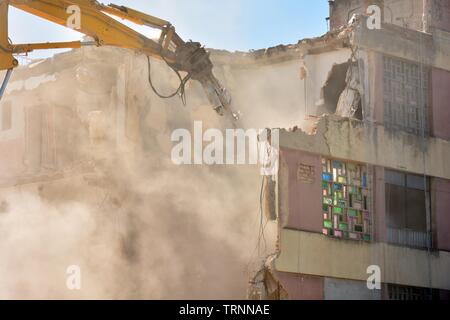 Gran maquina demoliendo un Viejo edificio de Apartamentos Stockfoto