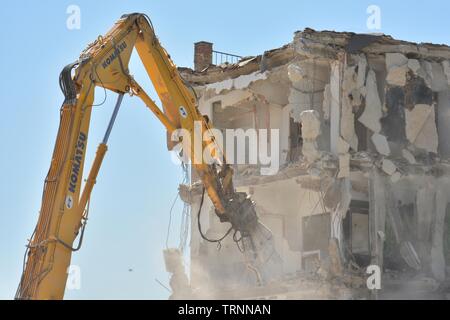 Gran maquina demoliendo un Viejo edificio de Apartamentos Stockfoto