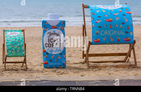 Jimmys Iced Coffee Liegestühle im Bournemouth Beach, Dorset UK im Juni - Jimmys Iced Coffee Original Caffe Latte, Hafer Latte Milchprodukte frei Stockfoto