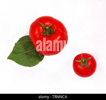 Frische Tomaten auf einen Korb und ein Holzbrett. Zusammen mit Wassertröpfchen. Stockfoto