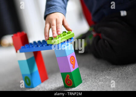 Ein junge Kleider in Gap und Maske spielt mit Lego duplo Bausteine Stockfoto