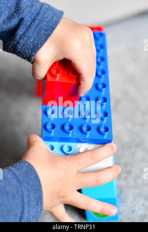 Ein junge Kleider in Gap und Maske spielt mit Lego duplo Bausteine Stockfoto