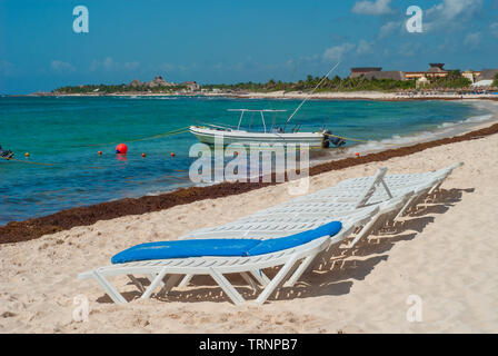 Fischerboot und Liegestühle am Strand von Tulum, in der mexikanischen Halbinsel Yucatan Stockfoto