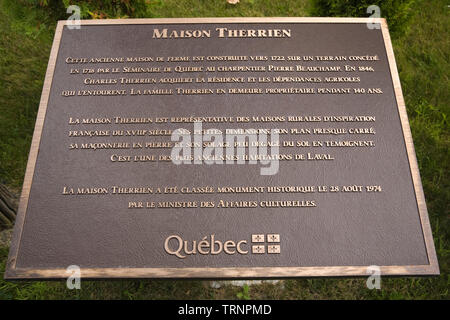 Nahaufnahme einer Bronze Metall historischen Informationstafel vor einem Alten 1722 Canadiana Landhausstil home Maison Therrien Stockfoto