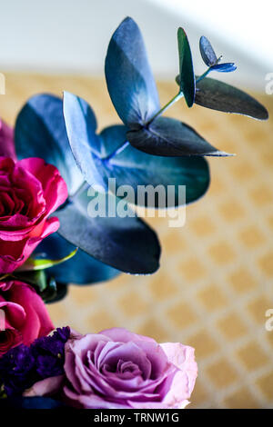Eine Luftaufnahme einer Innen- Anordnung der Rosen mit schöner Duft, von Farbe in eine Vase für den Innen- Anzeige der verschönert mit Rosa und Lila Stockfoto
