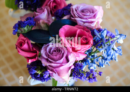 Eine Luftaufnahme einer Innen- Anordnung der Rosen mit schöner Duft, von Farbe in eine Vase für den Innen- Anzeige der verschönert mit Rosa und Lila Stockfoto