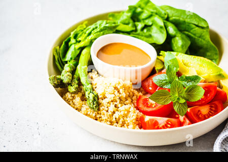 Grüner Salat mit Quinoa, Avocado und Spargel in einer weißen Schüssel. Veganes essen Konzept. Stockfoto