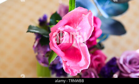 Eine Luftaufnahme einer Innen- Anordnung der Rosen mit schöner Duft, von Farbe in eine Vase für den Innen- Anzeige der verschönert mit Rosa und Lila Stockfoto