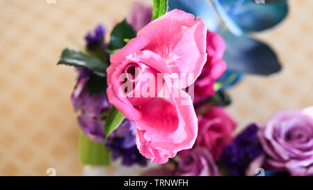Eine Luftaufnahme einer Innen- Anordnung der Rosen mit schöner Duft, von Farbe in eine Vase für den Innen- Anzeige der verschönert mit Rosa und Lila Stockfoto