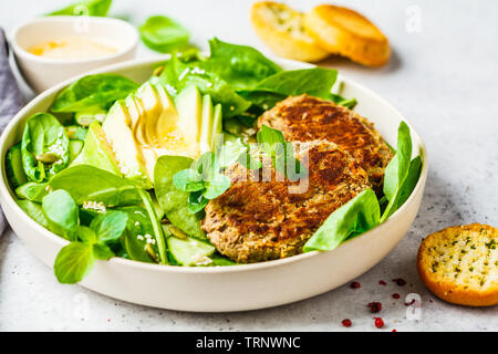 Grüner Salat mit Avocado, Gurke und Linsensuppe Schnitzel in eine weiße Platte. Stockfoto