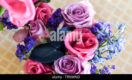 Eine Luftaufnahme einer Innen- Anordnung der Rosen mit schöner Duft, von Farbe in eine Vase für den Innen- Anzeige der verschönert mit Rosa und Lila Stockfoto