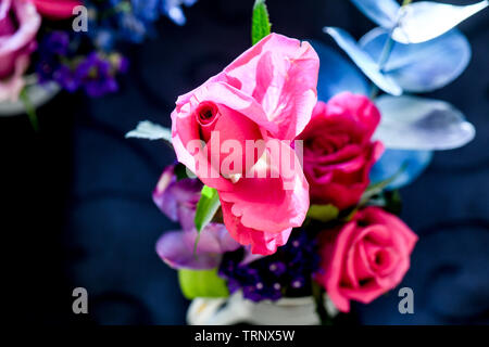 Eine Luftaufnahme einer Innen- Anordnung der Rosen mit schöner Duft, von Farbe in eine Vase für den Innen- Anzeige der verschönert mit Rosa und Lila Stockfoto