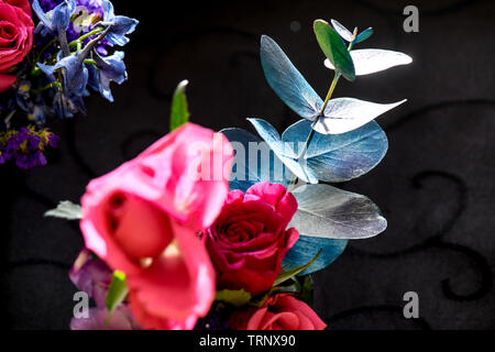 Eine Luftaufnahme einer Innen- Anordnung der Rosen mit schöner Duft, von Farbe in eine Vase für den Innen- Anzeige der verschönert mit Rosa und Lila Stockfoto