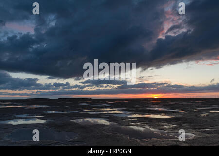 Die Sonne über Hilbre Island und Liverpool Bay an der Mündung des Dee Estuary, Merseyside, England Stockfoto