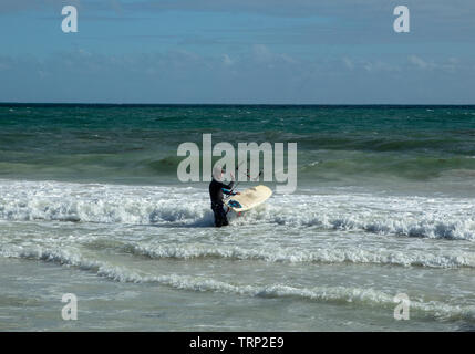 Kite Surfer surfen der leeren Küste von Mullaloo Beach, Western Australia erreichen hohe Geschwindigkeiten bei windigem Wetter Bedingungen an einem Wochentag Nachmittag. Stockfoto