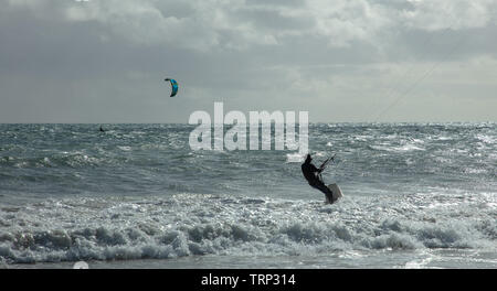 Kite Surfer surfen der leeren Küste von Mullaloo Beach, Western Australia erreichen hohe Geschwindigkeiten bei windigem Wetter Bedingungen an einem Wochentag Nachmittag. Stockfoto