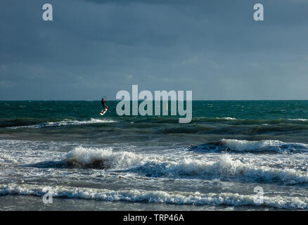 Kite Surfer surfen der leeren Küste von Mullaloo Beach, Western Australia erreichen hohe Geschwindigkeiten bei windigem Wetter Bedingungen an einem Wochentag Nachmittag. Stockfoto