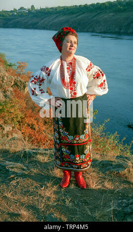 Ukrainische reife Frau in Tracht in der Nähe von Fluss Dnjepr, Ukraine Stockfoto