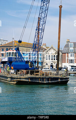 Hochformat eines selbstfahrenden Piling barge bewegt in Position ein Rammen für Bauarbeiten in Weymouth Hafen. Stockfoto